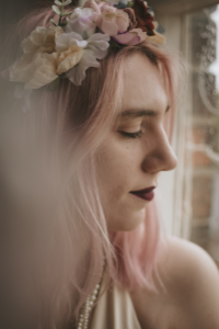 Close up of bride looking out of a window with a flower headband