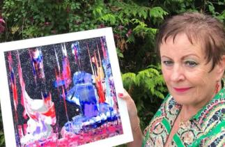 Linda Dent Mitchell holding her artwork 